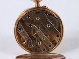 a close up of a pocket watch on a white surface