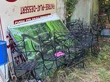 un tas de chaises et de tables devant un bâtiment