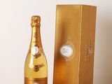 une bouteille de champagne posée sur une table en bois à côté d'un coffret