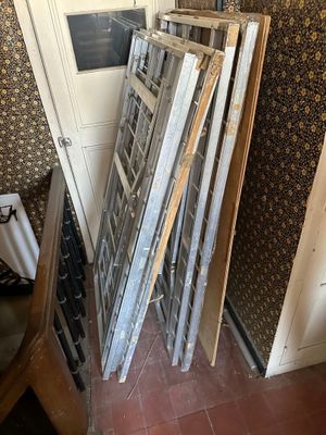 a pile of old windows in the corner of a room