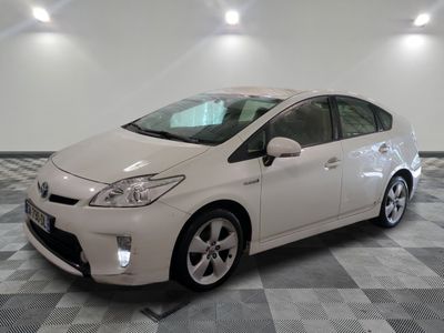 une photo d'une Toyota Prius blanche garée sur un sol à damier