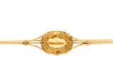 a close up of a gold tie bar with a faceted citrine stone