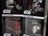three boxes of star wars action figures sit on a black surface