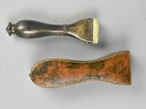 pair of antique silver and copper toothbrushes on a white surface