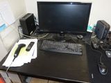 un bureau sur lequel se trouvent un ordinateur, un clavier, une souris et d'autres objets
