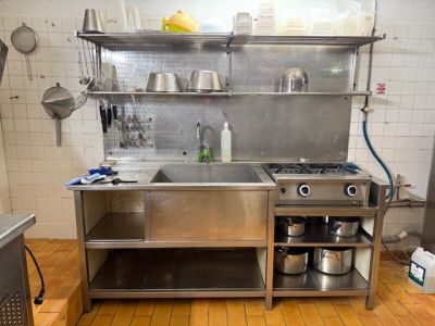une cuisine en acier inoxydable avec un évier et une cuisinière