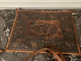a brown leather bag sitting on a marble floor