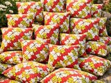 une pile d'oreillers posée sur une terrasse en bois