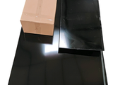 une boîte posée sur une table noire, à côté d'un carton