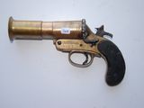un vieux pistolet posé sur une surface blanche