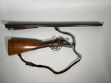 un gros plan d'un pistolet et d'un fusil posés sur une surface blanche