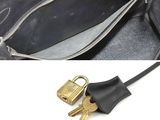 a black purse with a bunch of keys inside of it