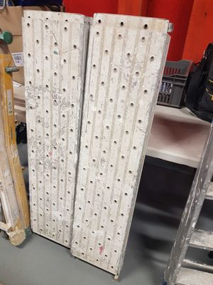 several pieces of wood sit on a table next to a ladder