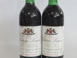 two bottles of red wine sitting next to each other on a table