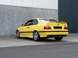 a yellow car that is parked in front of a building