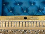 a close up of a gold plate on a blue chair
