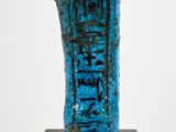 an image of a blue statue of a person on a wooden stand