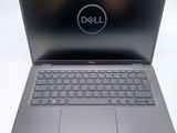 the dell laptop is open and ready to be used on the desk