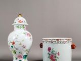 deux vases et un récipient, tous ornés de fleurs, posés sur une surface grise