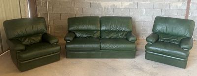 trois chaises en cuir vert et un fauteuil inclinable dans une pièce
