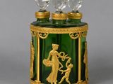 a green glass jar with a gold decoration on it