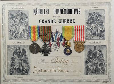 une vieille photo montrant un ensemble de médailles exposées dans un cadre