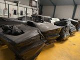 a lot of black plastic bags on a pallet in a warehouse
