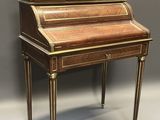 an antique writing desk with a wooden top and brass trimming
