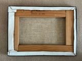 an old picture frame with a piece of wood in it