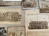 many old photographs of men and women on the wall