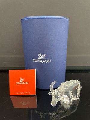 une figurine en cristal représentant un taureau et une boîte de Swarovski