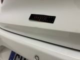 a close up of a white car with a sticker on it ' s bumper