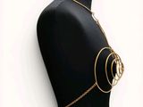 a black mannequin torso with gold chains and rings on it
