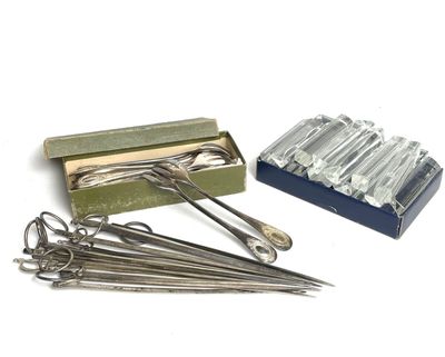 a box of needles and a pair of scissors on a table