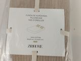 packaging of a tan and white striped bed sheet with a tag on it