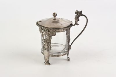 a small silver teapot with a glass in it