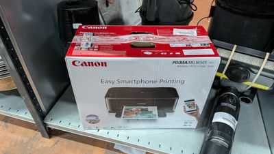 une imprimante Canon posée sur une étagère dans un magasin