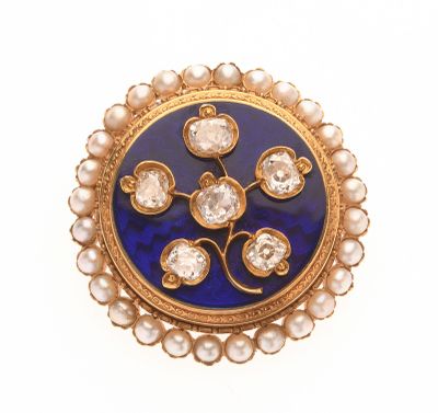 une photo d'une broche bleue et dorée ornée de perles
