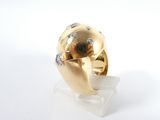 a gold and diamond ring sitting on a clear stand