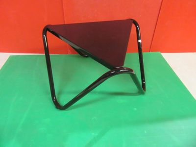 a small triangular table with a black top on a green mat