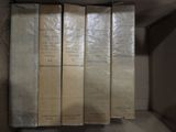 cinq livres dans une boîte, posés sur une étagère
