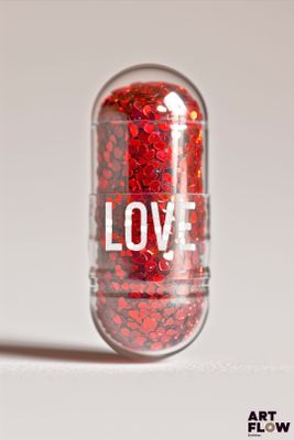 un comprimé contenant des paillettes rouges, posé sur une surface blanche