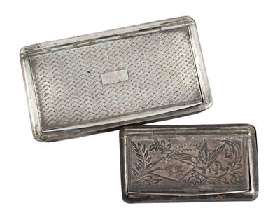 two antique silver cigarette cases with engraved designs on them on a white background