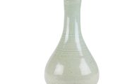 a green vase that is sitting on a white surface