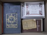 de nombreux livres dans une boîte, posés sur une table