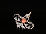 a close up of a diamond and coral pendant on a black background