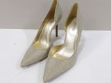 a pair of women ' s silver heels on a white surface