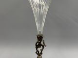 un vase en verre ancien posé sur un socle et orné d'un oiseau