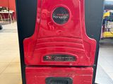 red and black oven sitting on pallets in a warehouse