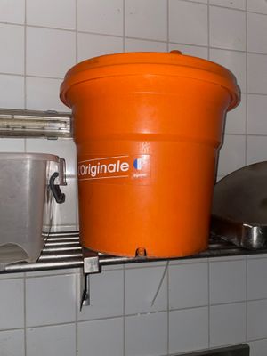un seau orange posé sur une étagère dans une cuisine